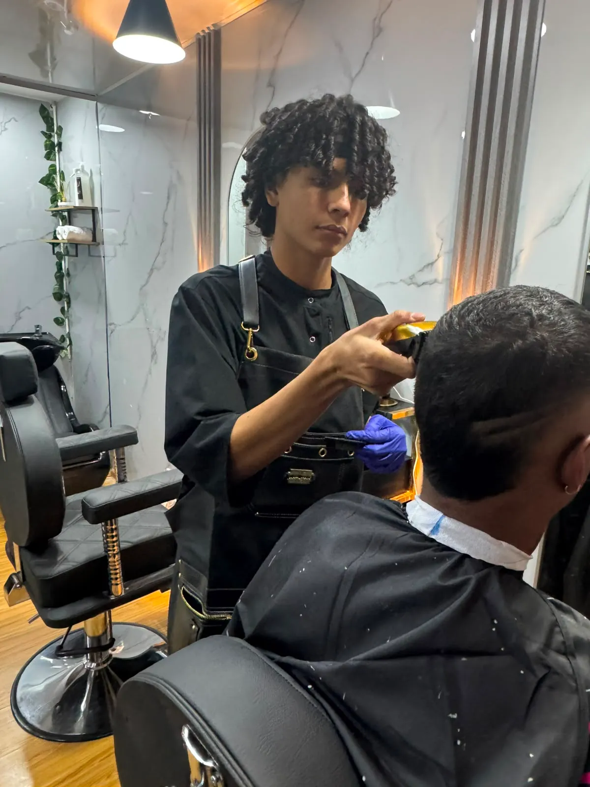 Barbero de Imora perfilando un fade con máquina
